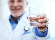 Photo of Doctor Handing Over a Glass of Water